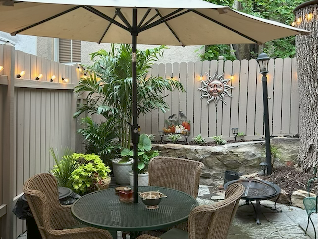 The walled cigar garden, with wicker seating under a large umbrella